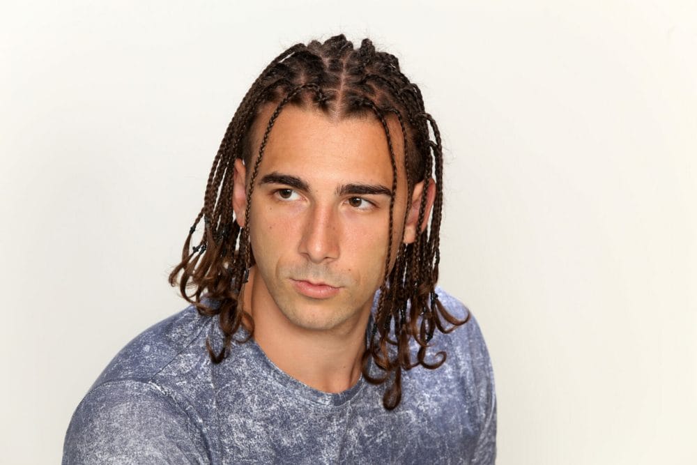 man with knotless box braids on a white background